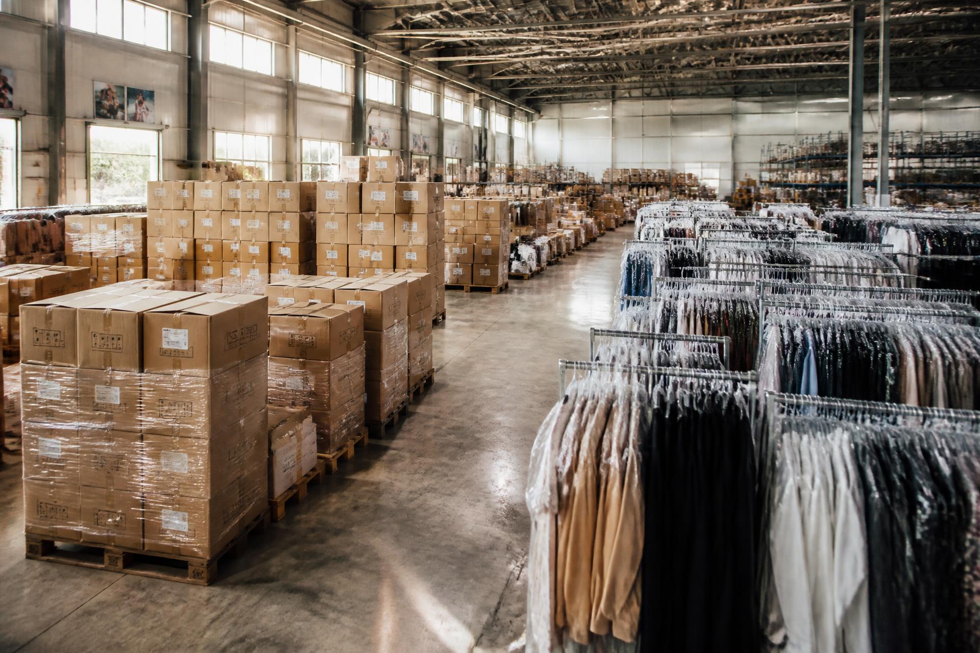 Magazijn met pallets, dozen en rekken vol kleding klaar voor transport